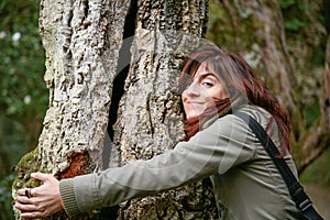 Smiling woman hugging a tree