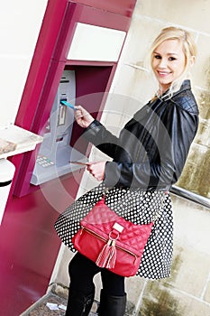 Smiling Woman Inserting a Card in an ATM