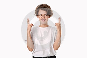Smiling woman isolated over white background holding fingers crossed for good luck