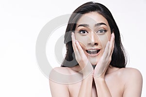 Smiling woman isolated on white background. Asian happy girl touching her face with clean fresh skin while looking at camera