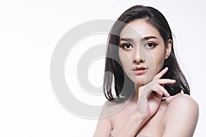 Smiling woman isolated on white background. Asian happy girl touching her face with clean fresh skin while looking at camera