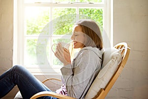 Smiling woman keeping warm with cup of tea