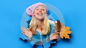 Smiling woman in knitted hat looking through paper hole. Woman fashion for autumn. Discount. Season sales.