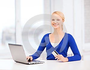 Smiling woman with laptop computer and credit card