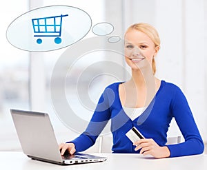 Smiling woman with laptop computer and credit card