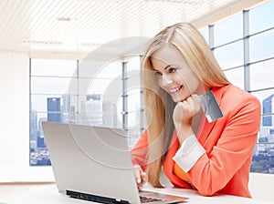 Smiling woman with laptop computer and credit card