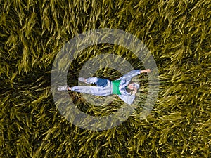 smiling woman laying down in wheat field