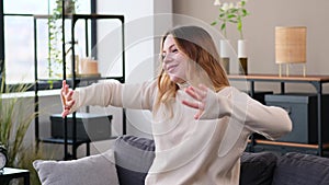 Smiling Woman Listening Music And Dancing At Home