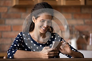 Smiling woman look at cellphone screen texting online