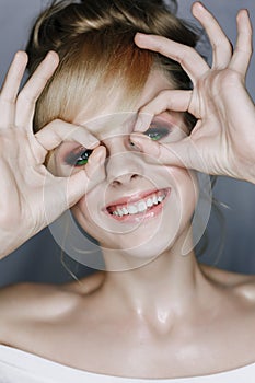 Smiling Woman Looking at Camera Through Fingers