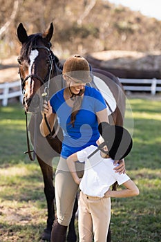 Smiling woman looking at girl with arms akimbo