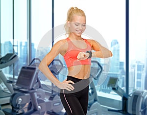 Smiling woman looking at heart rate watch in gym