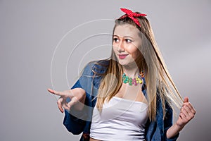 Smiling woman looks at side and shows a finger