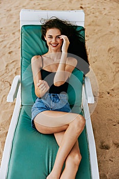 smiling woman lying beach resort lifestyle sea sunbed ocean sand blue