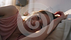 Smiling woman lying bed in morning. Serene calm female looking camera resting