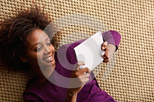 Smiling woman lying down with digital tablet