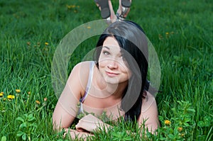 Smiling woman lying on grass.