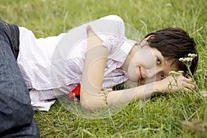 Smiling woman lying on grass in park