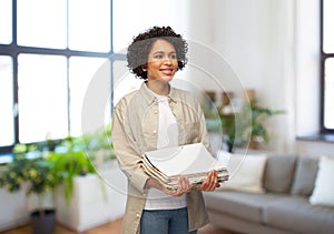 smiling woman with magazines sorting paper waste