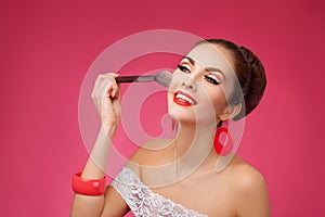 Smiling Woman with makeup brush. She is standing