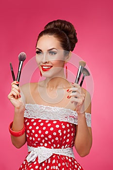 Smiling Woman with makeup brushes. She is standing