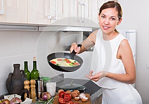 smiling woman making omelet