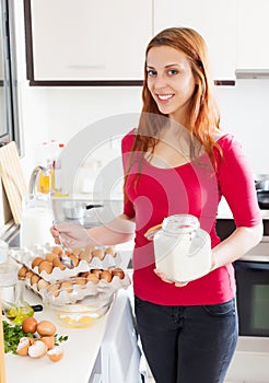 Smiling woman making omelet with flour