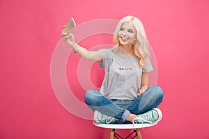 Smiling woman making selfie photo on smartphone