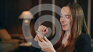 Smiling woman making video call on mobile phone in living room