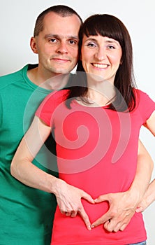 Smiling woman and man, heart shape over belly