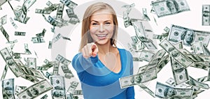 Smiling woman with money pointing finger on you