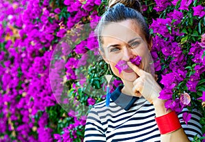 Smiling woman near colorful magenta flowers bed having fun time