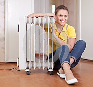 Smiling woman near warm radiator