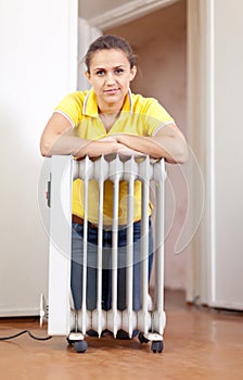 Smiling woman near warm radiator