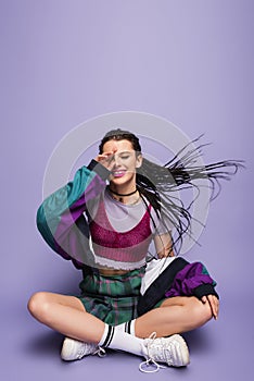 smiling woman in nineties attire sitting