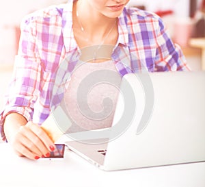 Smiling woman online shopping using computer and credit card in kitchen