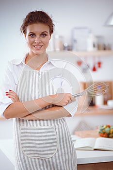 Smiling woman online shopping using computer and credit card in kitchen . Smiling woman