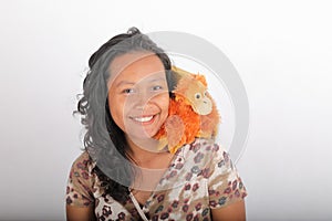 Smiling woman with orangutan toy on shoulder