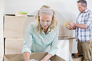 Smiling woman packing mug in a box