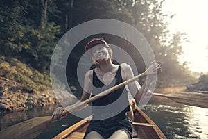 Smiling woman paddling on a lake
