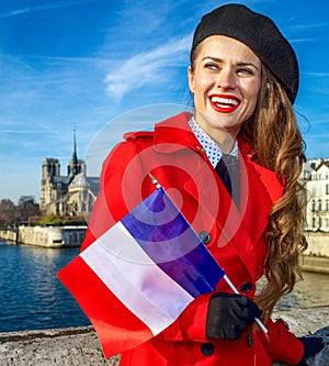 smiling woman in Paris with French flag looking into the distance