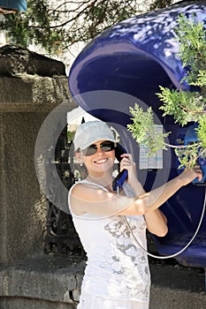 Smiling woman at payphone