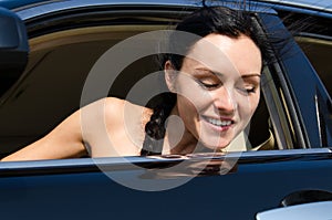 Smiling woman peering out of car