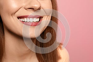 Smiling woman with perfect teeth on color background
