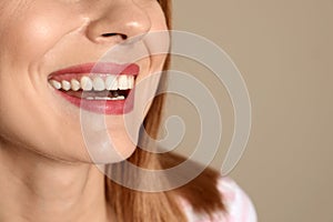 Smiling woman with perfect teeth on color background, closeup.