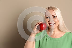 Smiling woman with perfect teeth and red apple