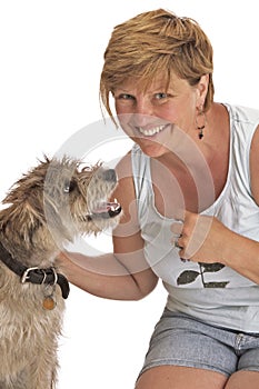 Smiling woman pets cute shaggy dog