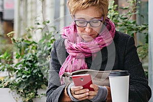 Smiling woman with phone in cafe