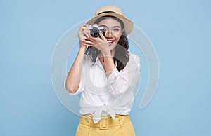 Smiling Woman photographer is taking images photo with dslr camera isolated studio blue background