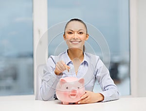 Smiling woman with piggy bank and cash money